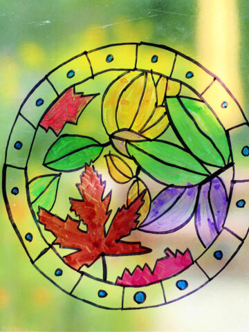 Hand drawn and colored circular design of leaves on clear vinyl window decal.