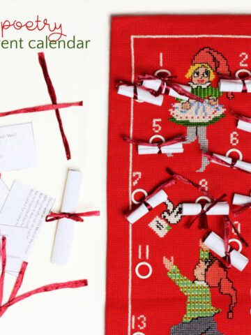 Embroidered advent calendar with small scrolls and paper with poems and ribbons.