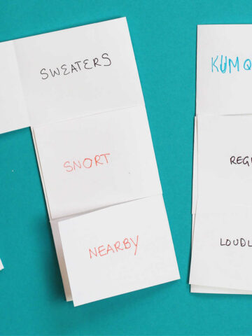 Two Funny flips paper games; one partially open. Each paper shows a column of words: noun-verb-adverb.