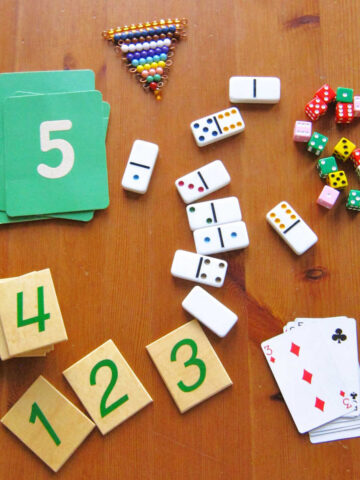 Piles of number cards, tiles, dominoes, playing cards, beads and colored dice read for number matching game.