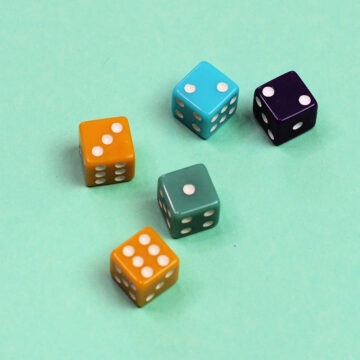Five dice on green background.