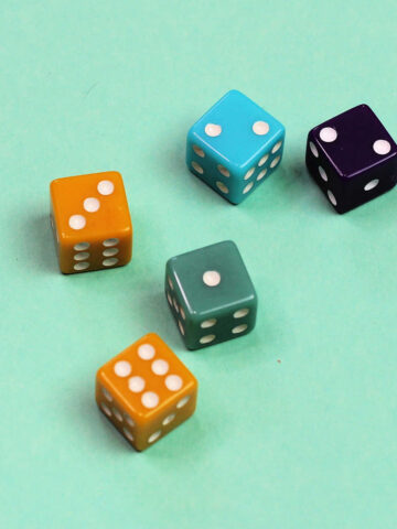 Five dice on green background.