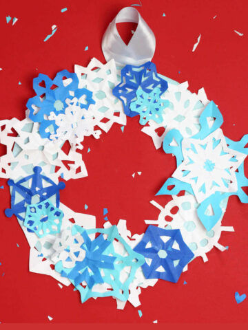 White and blue paper snowflakes on wreath.