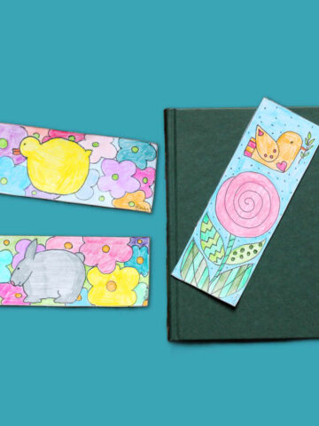 Three colorful spring themed bookmarks featuring flowers, bird, chick and bunny, next to a book.